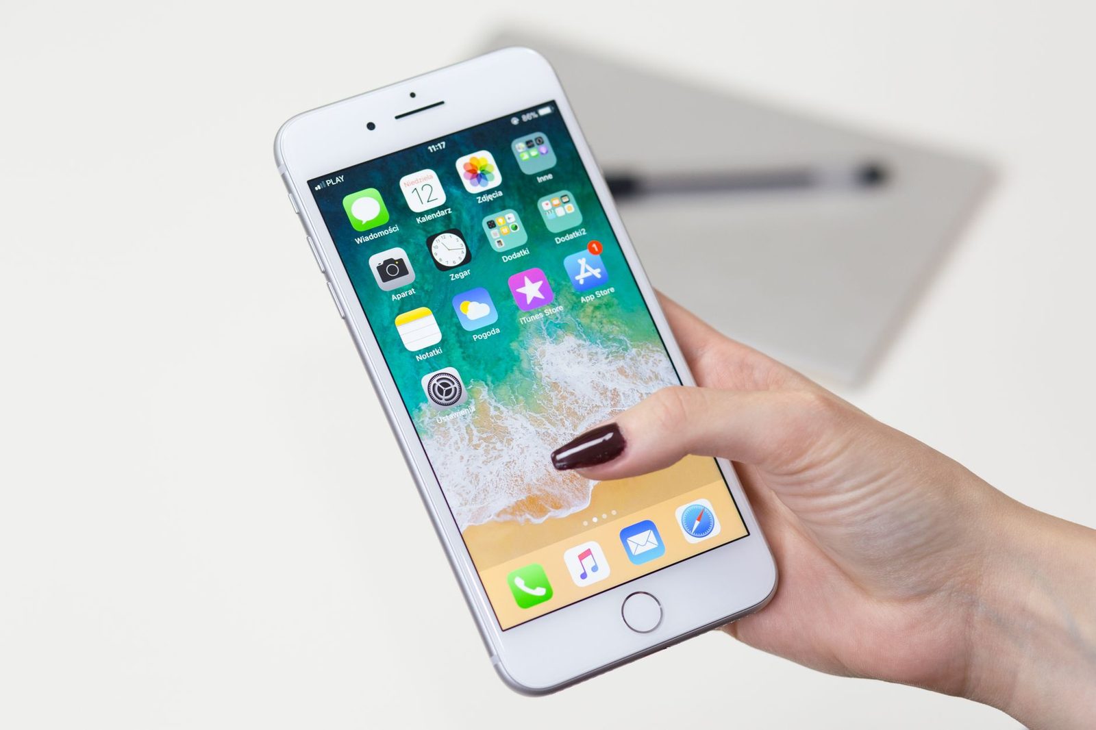 Mano che tiene uno smartphone con la schermata home e l'icona dei messaggi