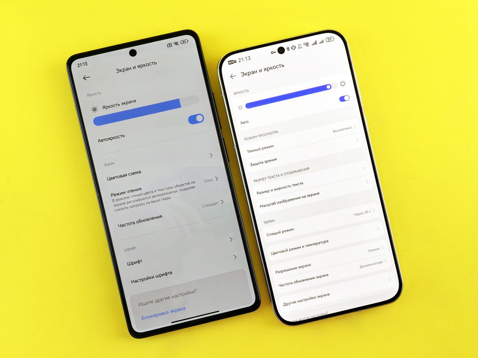Two smartphones lying on a yellow background, showing the display and brightness settings menus